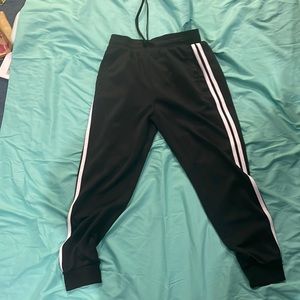 black sweat pants with two white stripes going down the sides